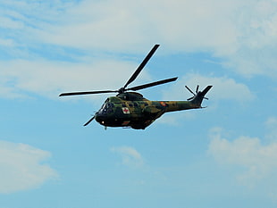green camouflage helicopter flying