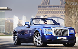 blue Rolls Royce convertible coupe parked on gray concrete pavement during daytime