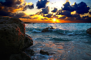 beach shore with rocks during golden time HD wallpaper