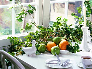 orange and green fruits with leaves on table