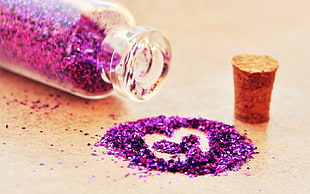 purple glittery beside a cork lid and glass bottle