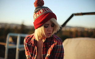 woman wearing red and black plaid dress shirt and red bauble cap