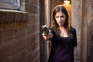 woman holding gun beside wall HD wallpaper