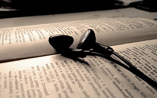 black earphones on book page HD wallpaper