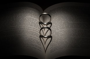 two silver-colored rings on book page