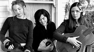 grayscale photography of three women using instruments