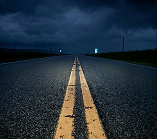 landscape photography of road under cloudy sky during nighttime