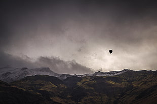 hot air balloon on top of a mountain photo