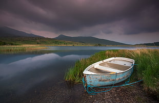 teal and white paddle boat under gray sky, gader, snowdonia