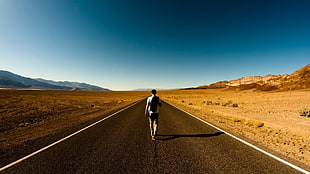 man walking on middle of road surrounded by desert, road, desert, walking, men