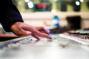 selective focus photo of person using audio equalizer \