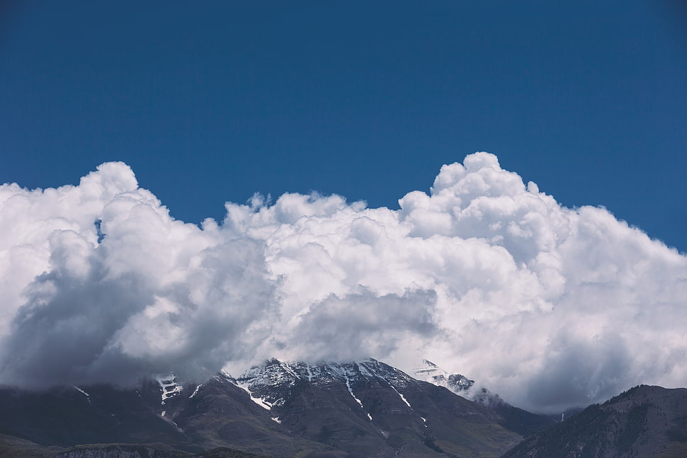 gray mountain sorrounded by cloud photo in daytime HD wallpaper