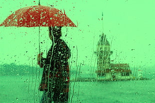 man holding umbrella infront of Maiden's Tower, Turkey, istanbul