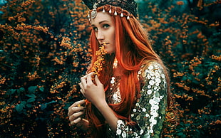 photo of woman with red hair holding brown clustered flower
