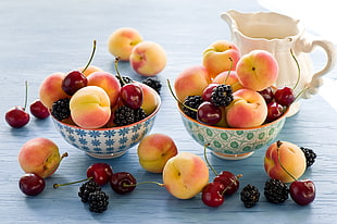 lot of apples and cherries on bowls HD wallpaper