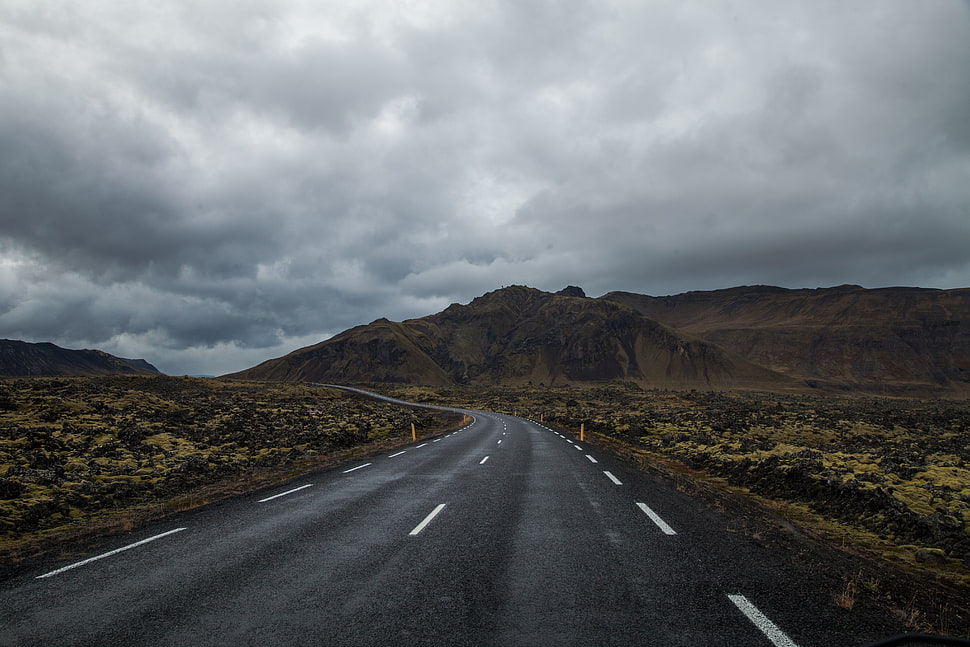 brown mountain range under gray cloudy sky during daytime HD wallpaper