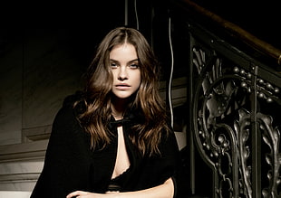 woman wearing black long-sleeved top standing beside gray stair post HD wallpaper