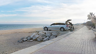 silver sedan and gray stone fragment lot, Jaguar XF, beach, sea, car