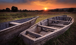 two gray wooden row boats on green grass field during dusk, tanzania, lake tanganyika HD wallpaper