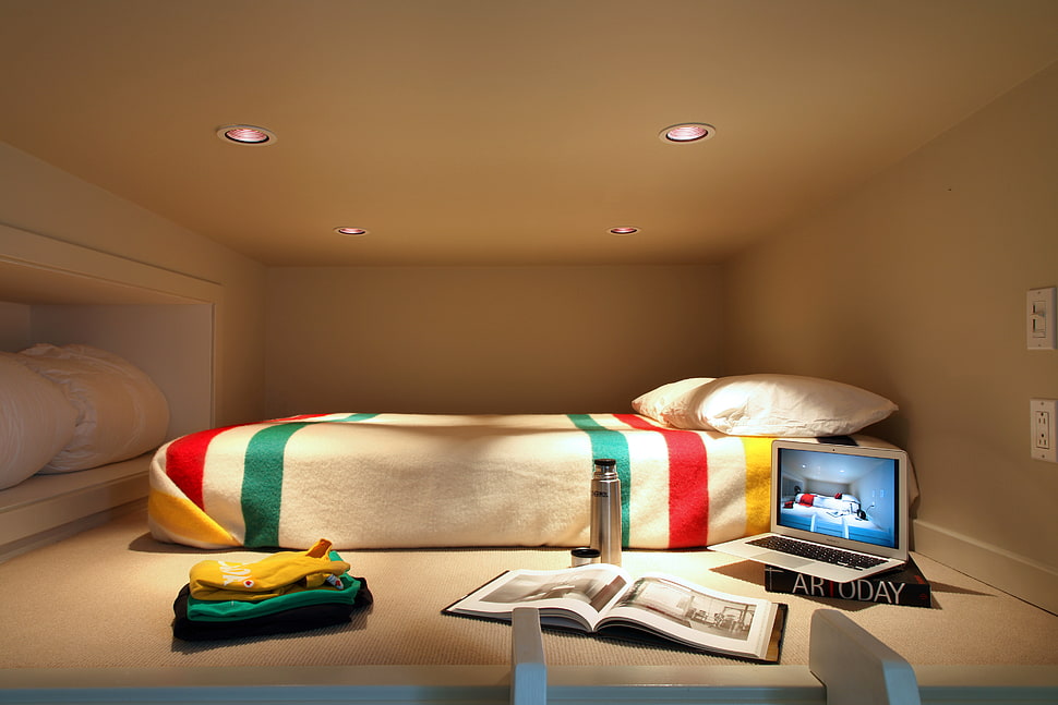 turned on gray laptop computer near white and red bed comforter HD wallpaper