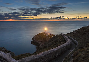 lighthouse near body of water during su\nset, south stack