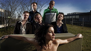 topless woman in front of five man