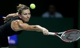 woman in black tank top playing tennis