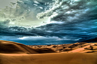 photograph of desert under blue sky during daytime