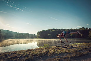 person stretching near body of water