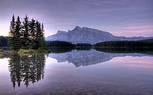 calm water of lake in a distance of a mountain at daytime