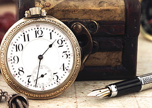 silver-analog clock with fountain pen