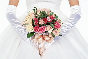 woman in white wedding dress holding bouquet of rose