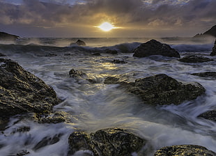 rocks and sea waves during golden hours HD wallpaper