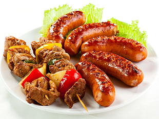 grilled sauges and skewered meat in plate