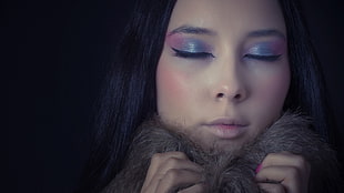 woman with full face makeup holding brown fur coat