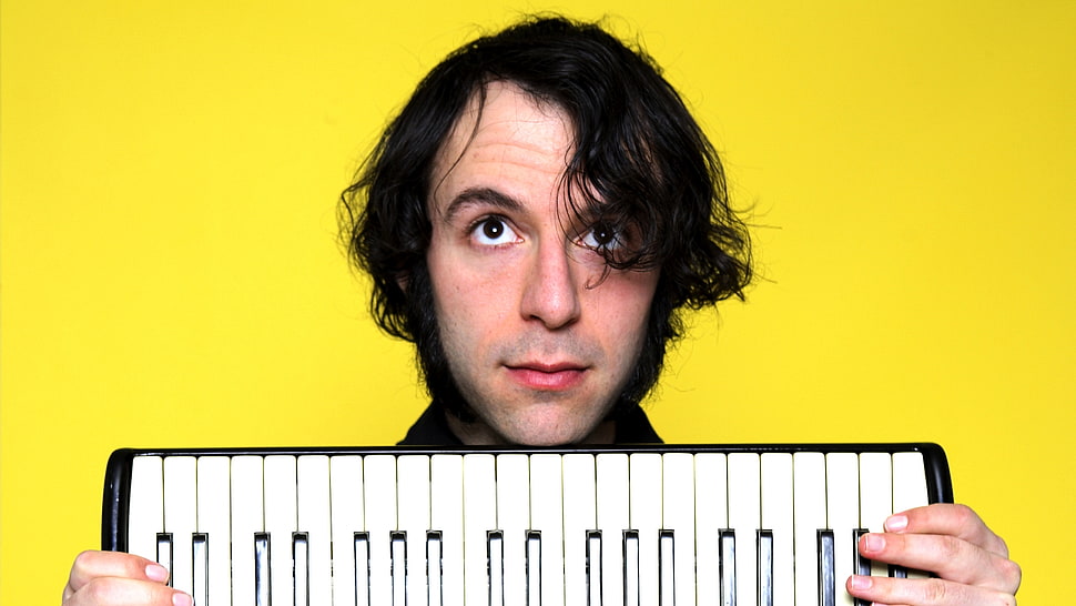 man holding white and black electronic keyboard HD wallpaper