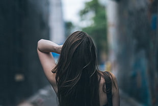shallow focus photography of woman holding her hair