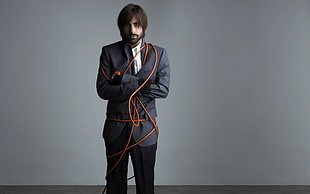 man wearing black suit and black pants with orange rope