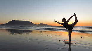 silhouette photography of woman in yoga pose during golden hour