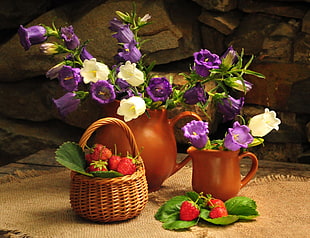 white and purple flowers in brown clay vase