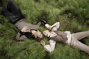man and woman lying on green grass during daytime