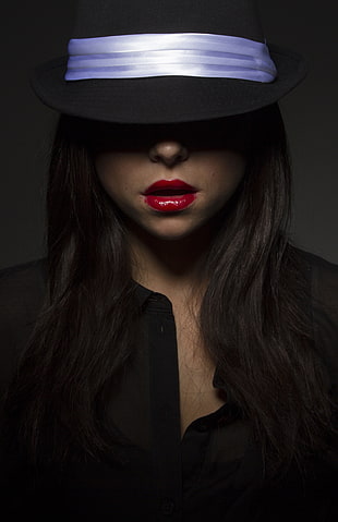 photo of woman in black button-up top with black hat
