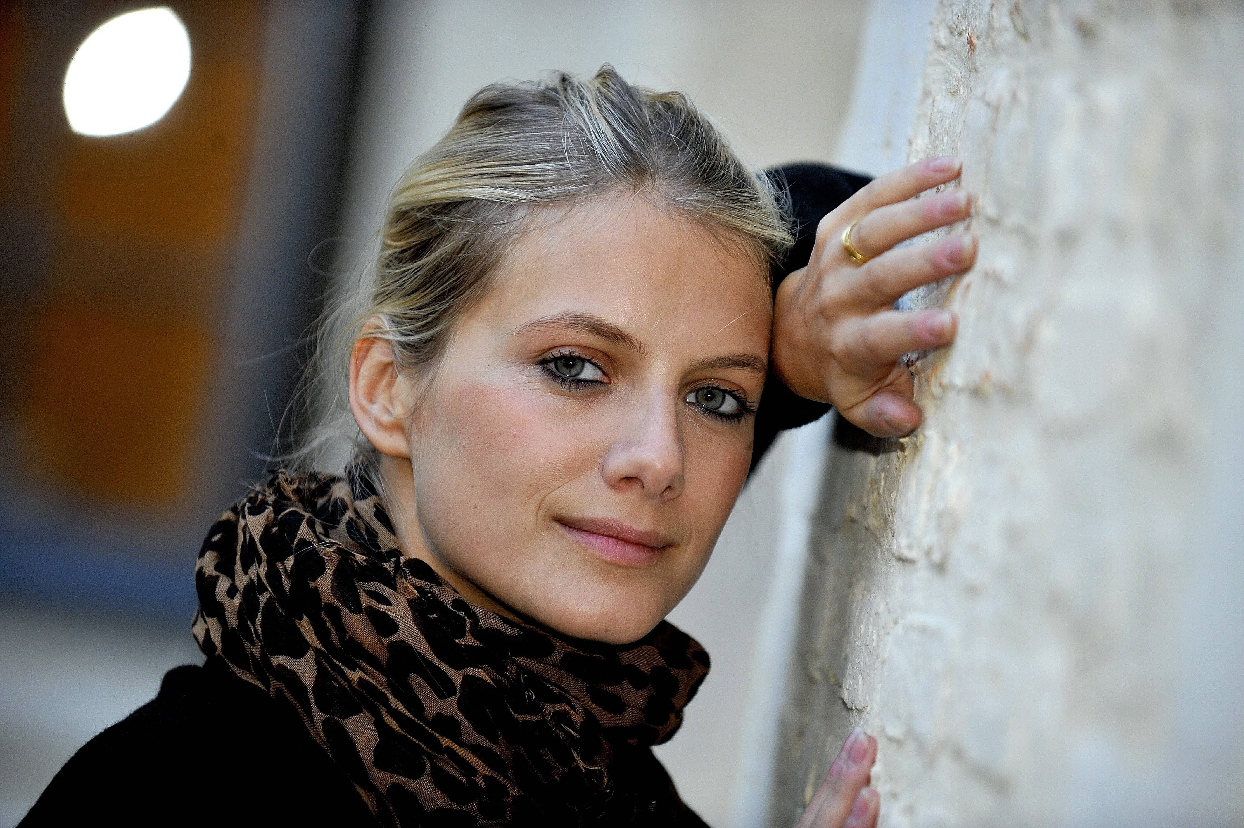 woman wearing black and white leopard-pattern scarf near wall