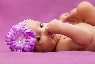 baby wearing purple flower headband