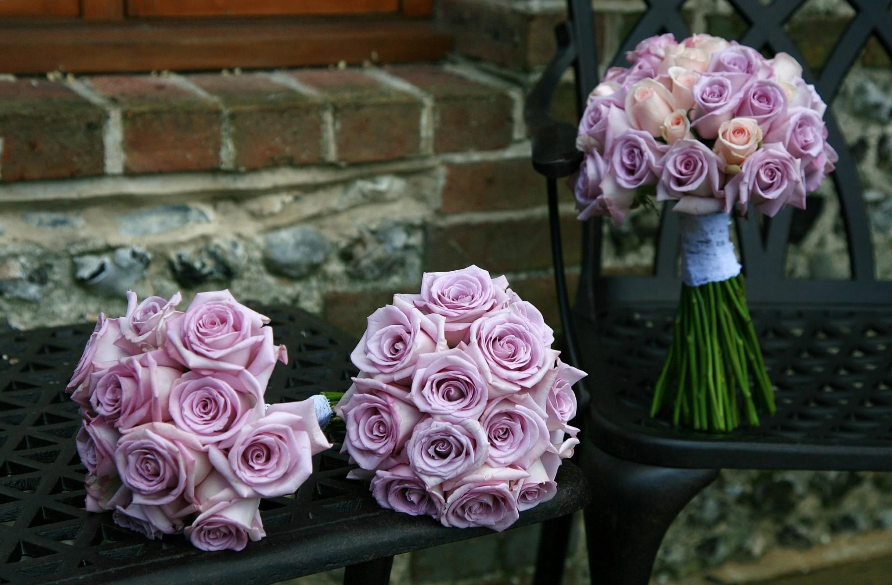 three bouquet of purple roses on black table