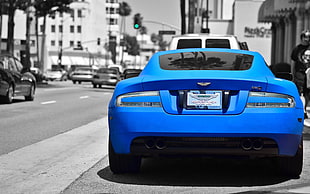 selective color photography of sports car beside road