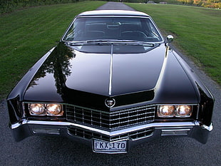 vintage black Cadillac car on gray asphalt road
