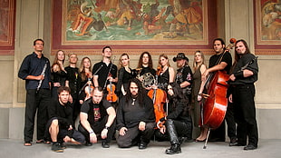 musicians wearing black shirts in front of painting