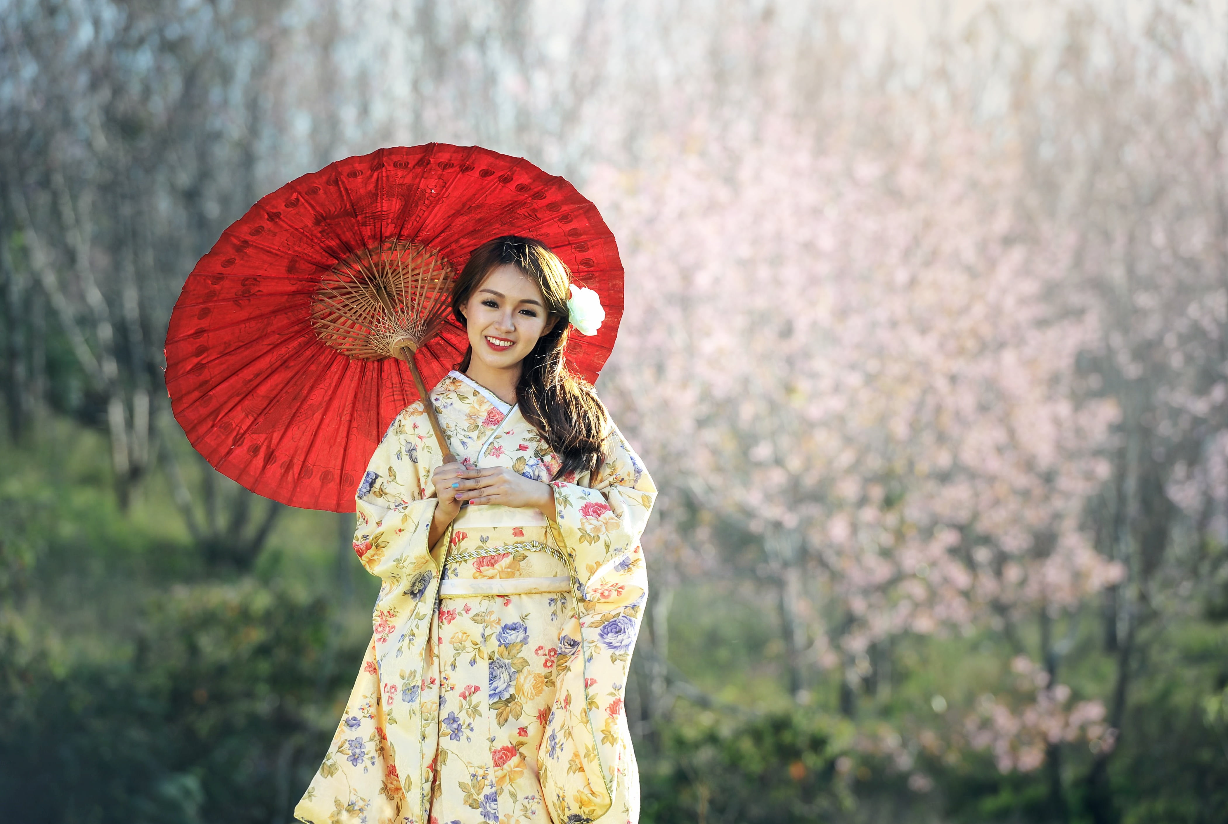 brown haired woman in yellow floral kimono dress holding umbrella during daytime