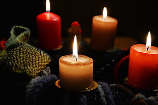 selective focus photography of four pillar candles